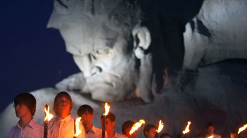Беларусские школьники держат факелы перед Брестской крепости во время церемонии в годовщину нападения Германии на Советский Союз. Брест, Беларусь