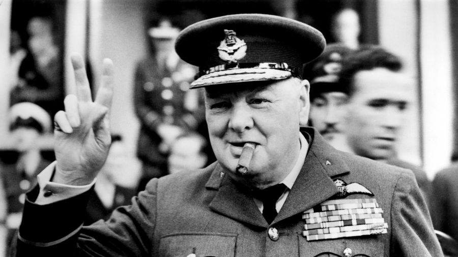 Winston Churchill pokazuje swój słynny znak zwycięstwa „V”, otwierając nową kwaterę 615 (hrabstwo Surrey) dywizjonu RAAF (Royal Auxiliary Air Force) w Croydon, 1948 r. Fot. Central Press / Hulton Archive / Getty Images
