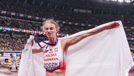 Radość Marii Żodzik po zdobyciu wicemistrzostwa świata (fot. Getty) Zdjęcie lekkoatletki Marii Żodzik, uśmiechniętej, stojącej na stadionie po zawodach, owiniętej flagą Polski z medalem na szyi, w biało-czerwonym stroju z napisem "POLSKA" (fot. Getty).
