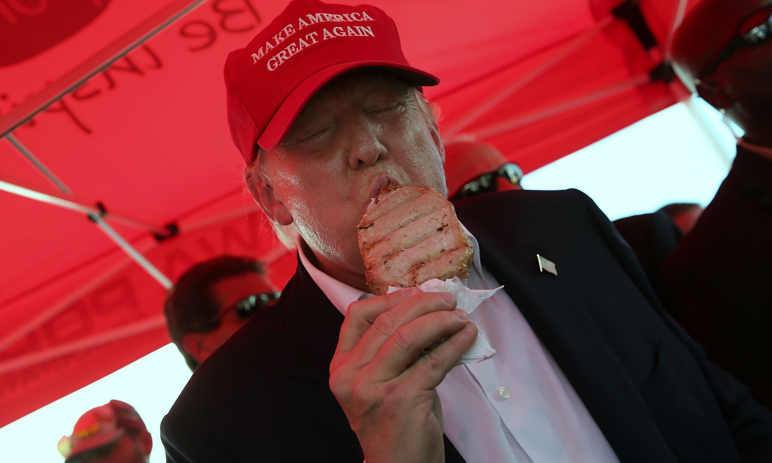 Des Moines, Iowa, 15 sierpnia 2015 r. Donald Trump, jeszcze jako republikański kandydat na prezydenta USA Part, zjada kotlet schabowy na patyku podczas targów Iowa State Fair. Prowadził kampanię i zwiedzał targi. Fot. Win McNamee / Getty Images