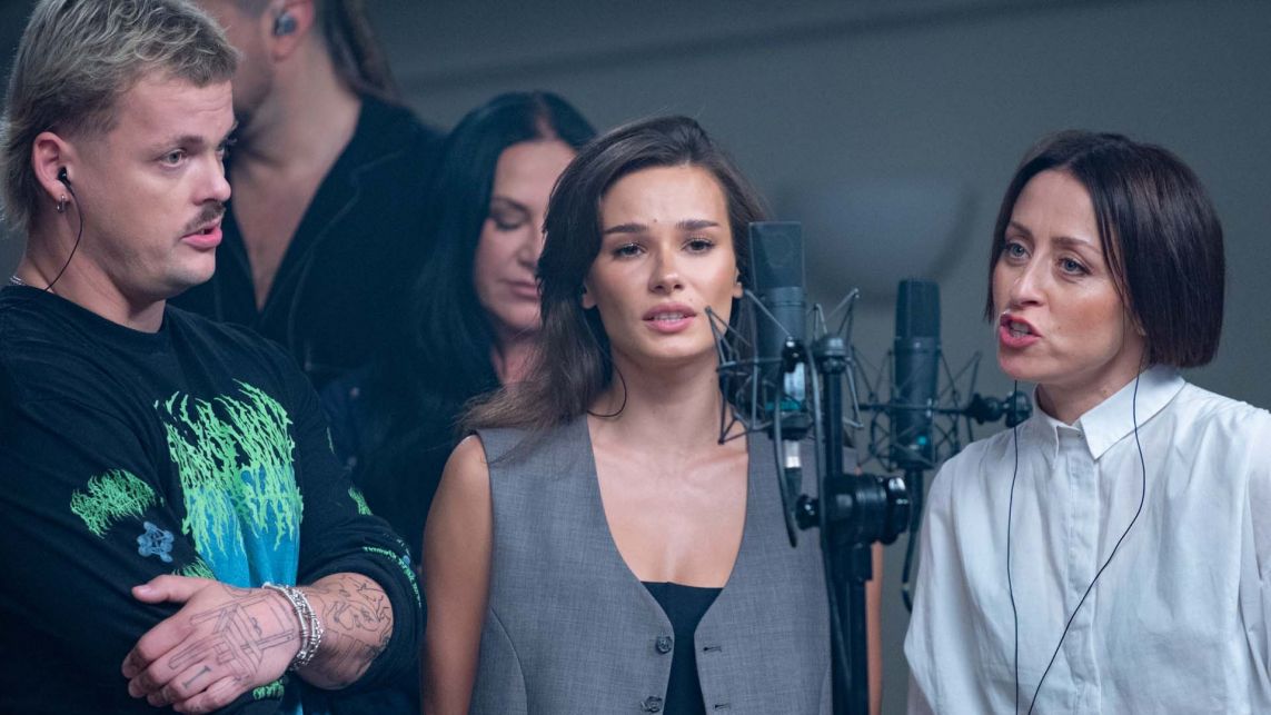 Zdjęcie z nagrań piosenki „Moja i twoja nadzieja”. Natalia Szroeder, Natalia Przybysz i Błażej Król stoją przy mikrofonie i wykonują utwór dedykowany osobom, które ucierpiały w trakcie powodzi. Po ich minach widać, że jest to dla nich emocjonujące przeżycie. Premiera piosenki i teledysku odbędzie się w programie „19:30” w TVP1 i TVP Info.