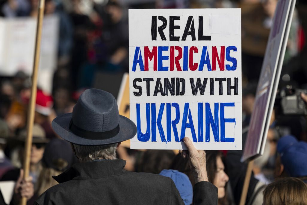 Дэманстрант трымае плакат з надпісам «Сапраўдныя амерыканцы за Украіну» падчас мітынгу пратэсту супраць палітыкі Дональда Трампа. Лос-Анджэлес, ЗША. 17 лютага 2025 года. Фота: Etienne Laurent / AP Photo / East News