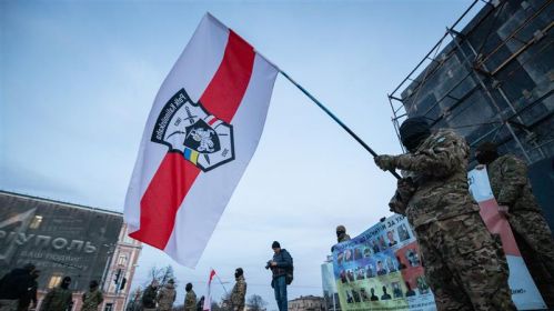Беларускія добраахвотнікі размахваюць сцягам палку Кастуся Каліноўскага падчас акцыі салідарнасці з салдатамі, якія ўтрымліваюцца ў расейскім палоне. Кіеў, Украіна. 14 сакавіка 2023 года. Фота: Oleksii Samsonov /Global Images Ukraine via Getty Images