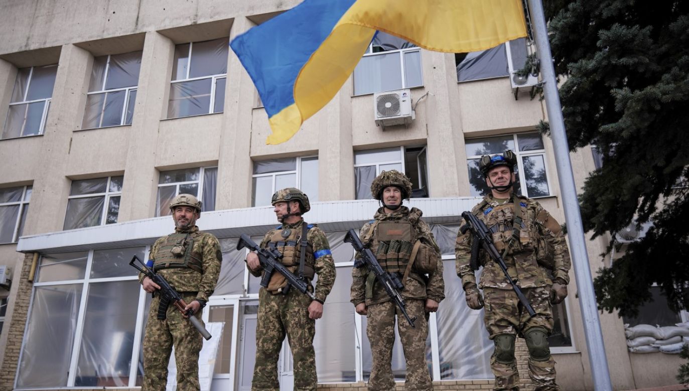 Ukraińscy żołnierze podczas wzniesienia flagi narodowej w niedawno zdobytym Łymaniu (fot. PAP/EPA/YEVGEN HONCHARENKO)