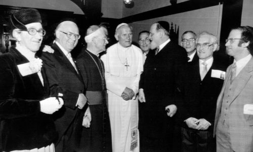 Papież Jan Paweł II wraz z biskupem Thomasem Hollandem z Salford (trzeci z lewej), spotkał się z Naczelnym Rabinem Zjednoczonego Królestwa Sir Immanuelem Jakobovitsem (czwarty od prawej) i innymi żydowskimi dygnitarzami, w klasztorze nazaretanek w Manchesterze. Fot. PA Images via Getty Images