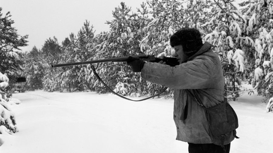 Rok 1969. Członkowie kółka myśliwskiego z Pisza w czasie polowania w okolicach wsi Jeże. Na zdjęciu jeden z myśliwych składający się do strzału. Fot. PAP/Stanisław Moroz