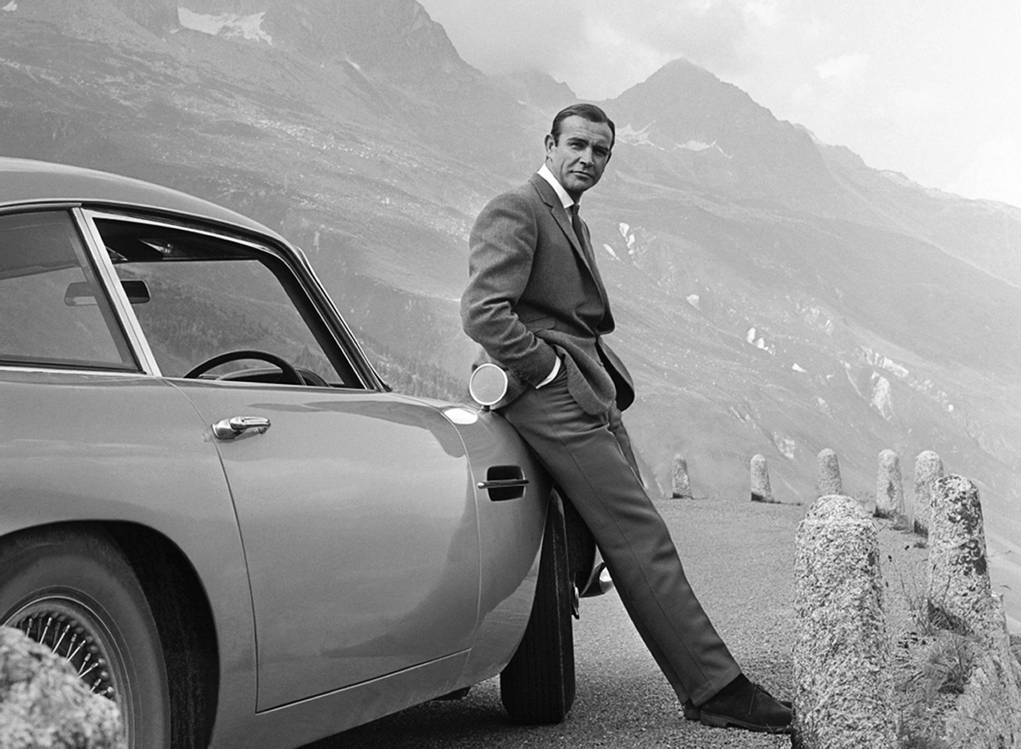 Sean Connery jako James Bond pozuje obok swojego Astona Martina DB5. Fot. Michael Ochs Archives/Getty Images