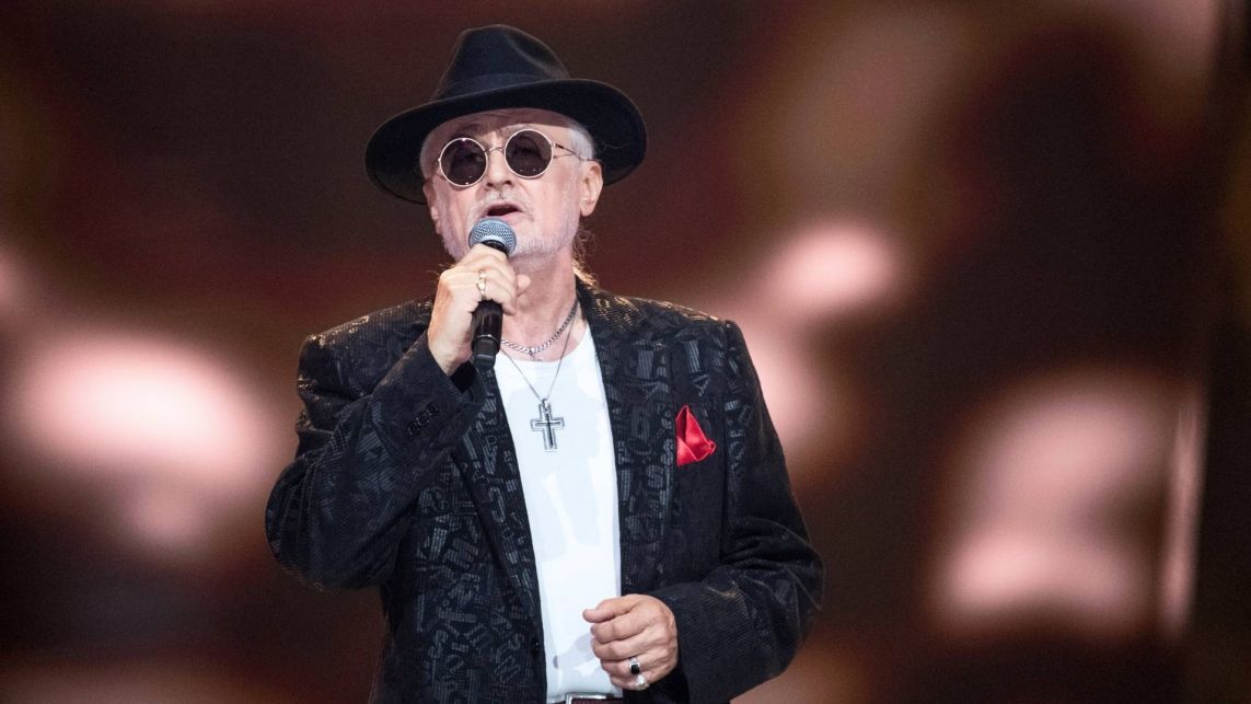 Krzysztof Kisiała to śpiewający didżej w czarnej marynarce i kapeluszu, który w programie „The Voice Senior” wykonał utwór „Che sarà” José Feliciano i grupy Ricchi e Poveri.
