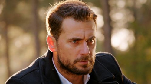 Kuzey wygląda na głęboko zamyślonego i skupionego. Jego intensywne spojrzenie i napięta mimika zdradzają determinację lub wewnętrzny gniew. Ciepłe światło zachodzącego słońca kontrastuje z jego surowym wyrazem twarzy, podkreślając emocjonalne napięcie chwili. Serial „Miłość i nadzieja” można oglądać w TVP2 i na stronie vod.tvp.pl.