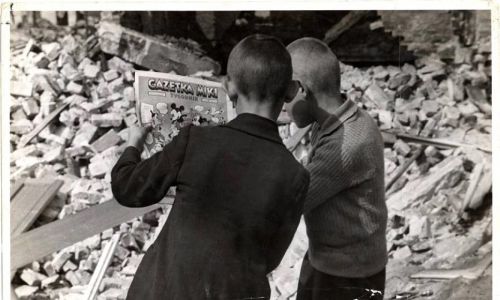 W gruzach zbombardowanego miasta chłopcy chwytają chwile dawnego dzieciństwa ¬tu czytają komiks o przygodach Myszki Miki Fot. Julien Bryan/domena publiczna