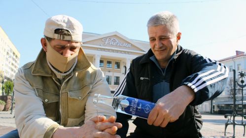 Мужчины моют руки водкой возле кинотеатра &laquo;Родина&raquo; в Могилеве. Фото: Nikolay TITOV/East News