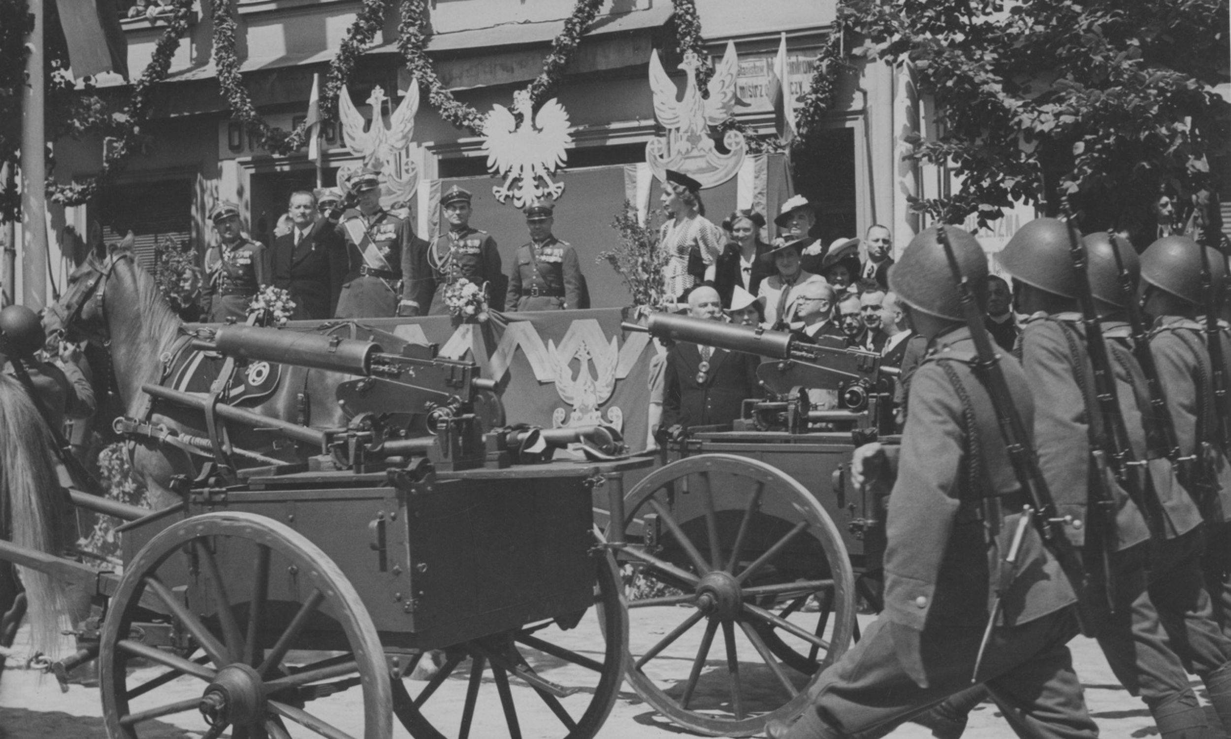 Parade of the 57th Infantry Regiment during the handing over of heavy machine guns financed by the National Defence Fund Committee in Nowy Tomyśl. Gen. Kazimierz Sosnkowski wearing a sash on the tribune. Browning heavy machine guns model 30 on carts. July 1938. Photo: NAC/IKC, Witold Pikiel. Catalogue number: 1-W-3015-6 