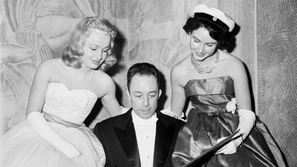 Albert Camus w towarzystwie dwóch młodych kobiet na przyjęciu noblowskim po odebraniu nagrody w 1957 r. Fot. Wikipedia