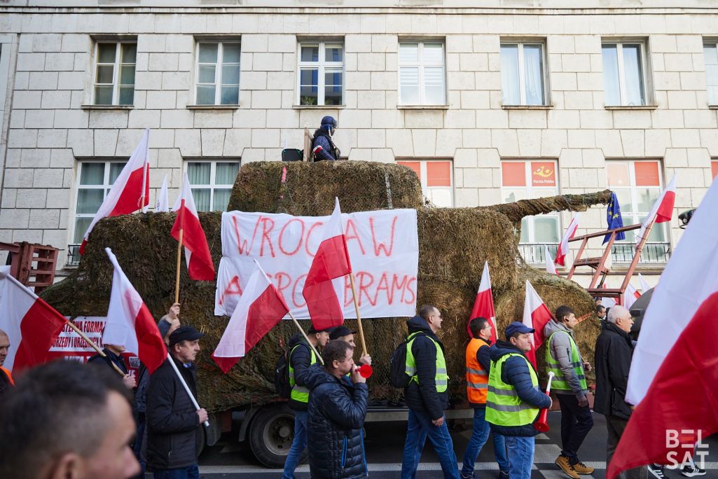 Фігура танка, зробленая са стагоў сена, на акцыі пратэсту польскіх фермераў, якія выступаюць супраць еўрапейскіх экалагічных законаў і імпарту прадуктаў з Украіны. Надпіс на танку: «Wrocław. Agroabrams». Варшава, Польшча. 27 лютага 2024 года. (Фота: Белсат)