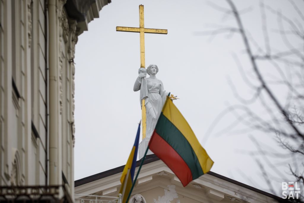 Літоўскі сцяг на фоне статуі на даху Кафедральнага касцёлу Святога Станіслава. Вільня, Літва. 21 лютага 2024 года. (Фота: Белсат)