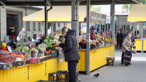 Женщина покупает продукты на Кальварийской ярмарке в Вильнюсе