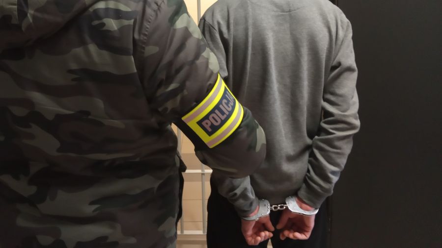 Policjant pionu kryminalnego z zatrzymanym.